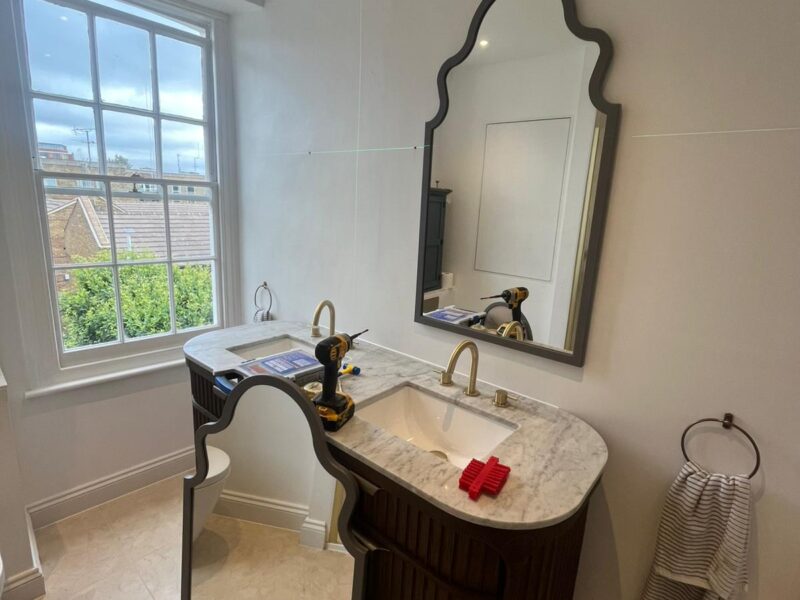 Handyman wall mounting TV and shelves in Hackney living room