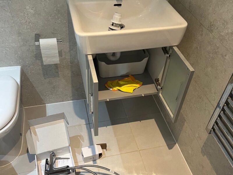 Plumbing handyman fixing sink in Hackney flat bathroom or kitchen